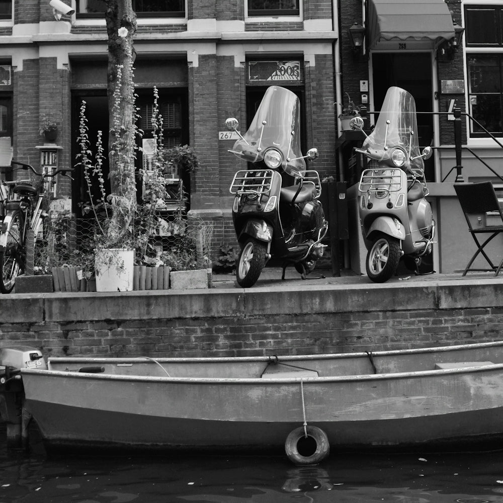 a couple of motor scooters parked next to a boat